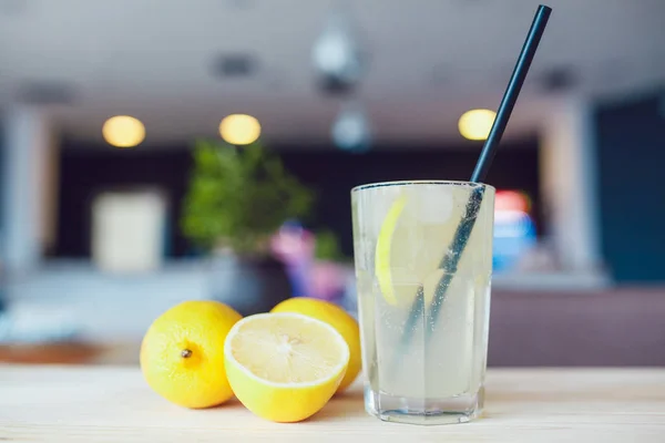 Un vaso de bebida refrescante fría con frutas y hielo sobre una mesa. Limonada de verano . — Foto de Stock