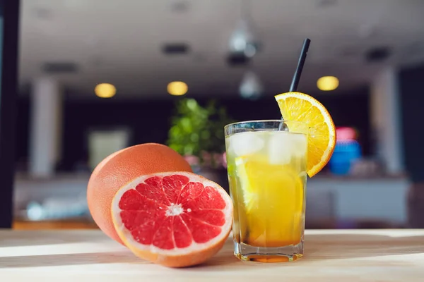 Vaso de bebida refrescante fría con frutas y pajitas de cóctel sobre una mesa . — Foto de Stock