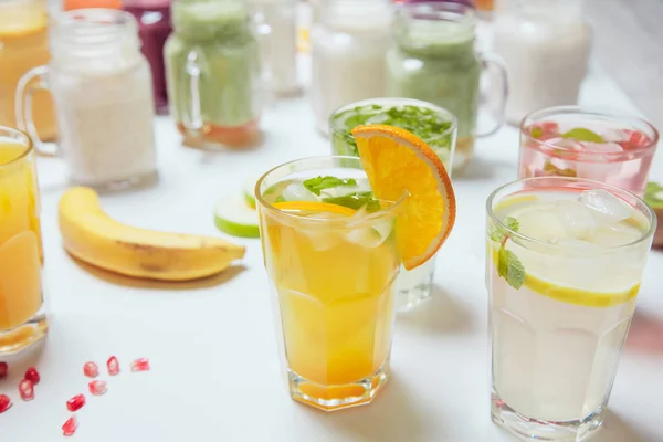 Los vasos de la bebida fría refrescante con las frutas y el hielo sobre la mesa. Limonada de verano . — Foto de Stock