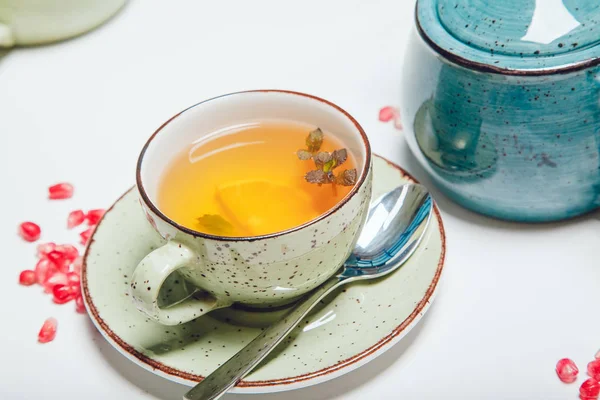 Tee in Tasse mit Minze und Zitrone auf weißem Tisch. — Stockfoto
