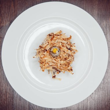 Bir yuva şeklinde salata ve bıldırcın yumurtası ile dekore edilmiş.