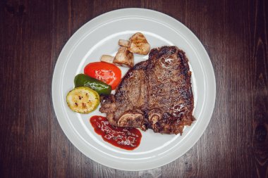 Izgara biftek ve bir tabakta sebze.