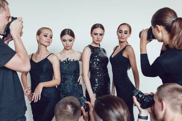 Fotografen paparazzi fotograferen van vrouwen in cocktail jurken. — Stockfoto