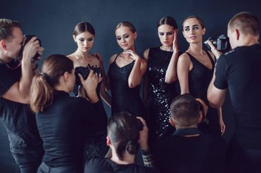 Fotoğrafçılar paparazzi kokteyl elbiseleri koyu arka plan üzerinde kadın fotoğrafları almak.