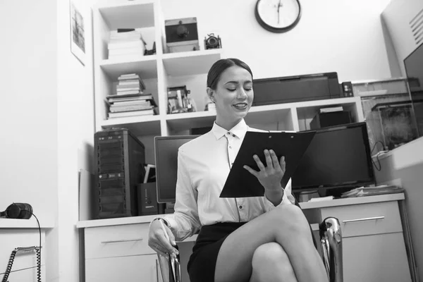 Επιχειρήσεων γυναίκα κάθεται στο γραφείο και την εξέταση εγγράφων. — Φωτογραφία Αρχείου