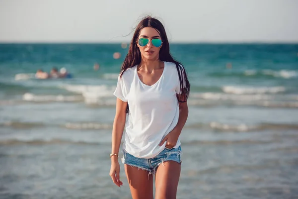 Meisje in een witte t-shirt op de achtergrond van de Oceaan. Mock-up. — Stockfoto