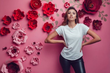 Çiçekli pembe bir arka plan üzerinde beyaz bir t-shirt seksi kadın.