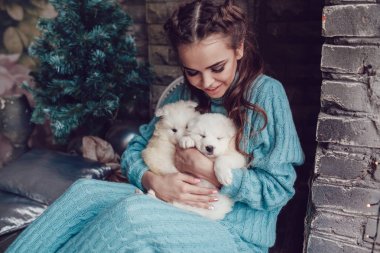 Çekici kız evde ve sevimli yavru ile eller üzerinde oturur. Noel.