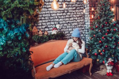 Sevimli yavru Noel ağacının yanında oturan güzel kadınla. Yeni yıl.