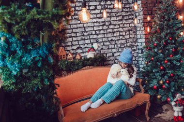 Sevimli yavru Noel ağacının yanında oturan güzel kadınla. Yeni yıl.