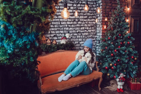美丽的女人与可爱的小狗坐在圣诞树附近。新年. — 图库照片