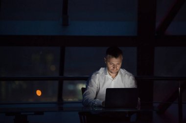 Laptop gece ofiste çalışan iş adamı.