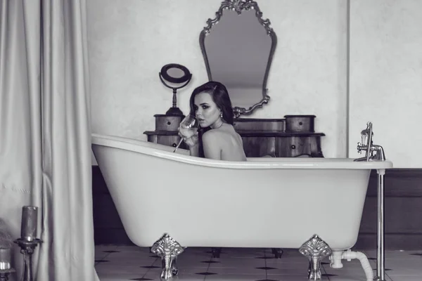 Hermosa mujer sexy relajada en el baño con una copa de vino . — Foto de Stock