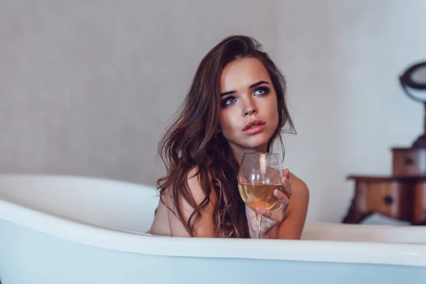 美しいセクシーな女性がワインのグラスとお風呂でリラックス. — ストック写真