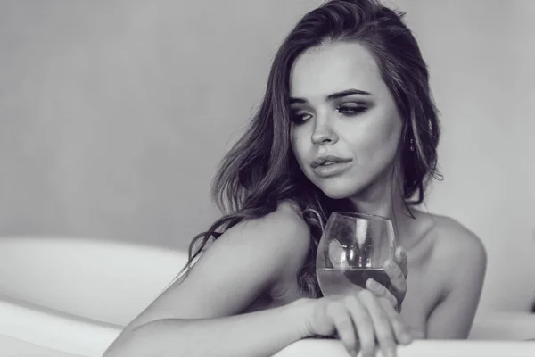 美しいセクシーな女性がワインのグラスとお風呂でリラックス. — ストック写真