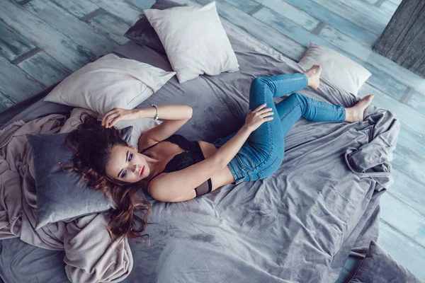 Sexy vrouw poseren op op bed thuis. — Stockfoto
