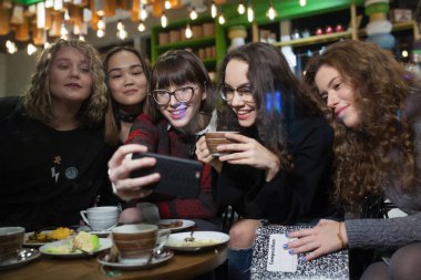 Pozitif genç grup yapmak selfies ve bir kafede vakit.