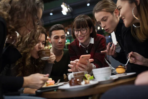 Grupa nastolatków pozytywny za pomocą smartfona i spędzić czas w kawiarni. — Zdjęcie stockowe