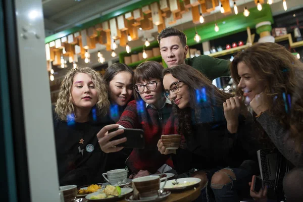 Gruppe positiver Teenager macht Selfies und verbringt Zeit in einem Café. — Stockfoto