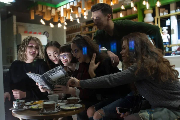 Gruppe von Jugendlichen macht Hausaufgaben im Café. — Stockfoto