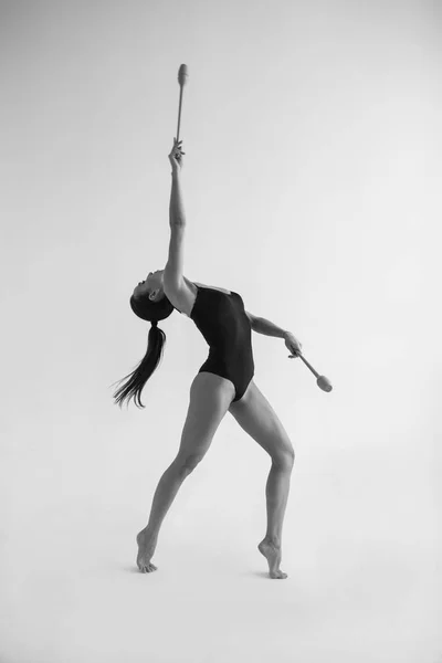 Красивая женщина гимнастка с булавами на белом фоне . — стоковое фото