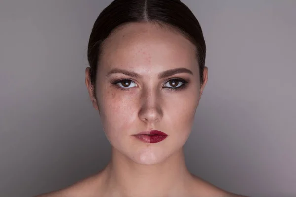 Mulher com maquiagem em um lado do rosto e sem maquiagem no segundo lado do rosto. Antes e depois da maquilhagem . — Fotografia de Stock