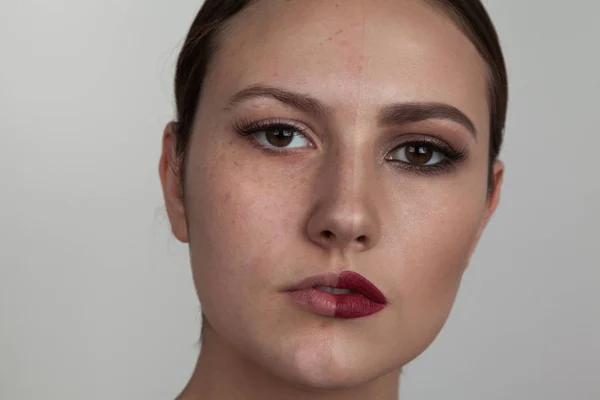 Женщина с макияжем на одной стороне лица и без грима на второй стороне лица. До и после косметики . — стоковое фото