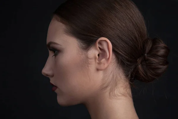 Perfil de una cara de mujer con maquillaje sobre fondo negro . — Foto de Stock