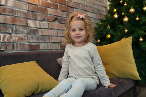 Une gentille petite fille en sweat blanc gris près du sapin de Noël. Maquette . — Photo