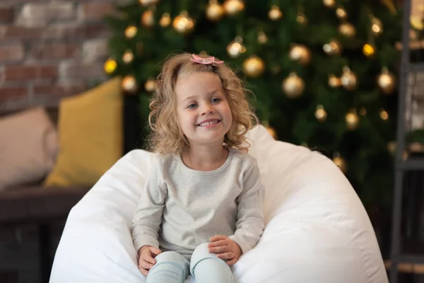 Une gentille petite fille en sweat blanc gris près du sapin de Noël. Maquette . — Photo