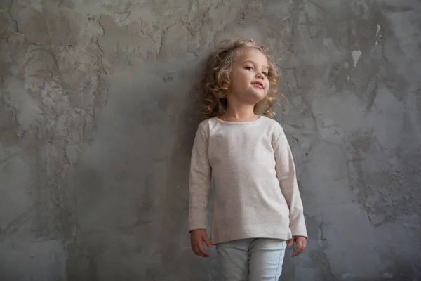 A nice little girl in a gray blank sweatshirt. Mock up. — Stock Photo, Image