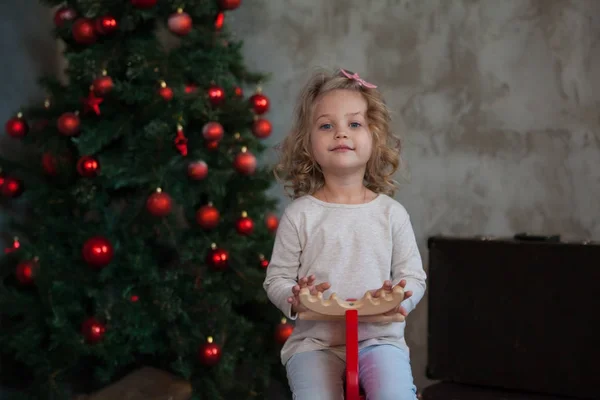 Une gentille petite fille en sweat blanc gris près du sapin de Noël. Maquette . — Photo