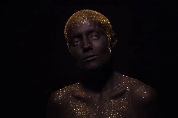 Retrato de una mujer hermosa con el cuerpo creativo arte brillante maquillaje. La cara está coloreada con pintura negra . — Foto de Stock