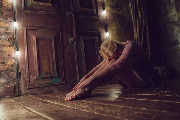 Красива блондинка сидить на дерев'яній підлозі . — стокове фото