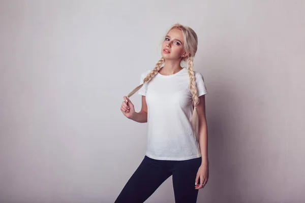 Όμορφο κορίτσι με δύο πλεξούδες σε ένα λευκό μπλουζάκι. Μακέτα. — Φωτογραφία Αρχείου