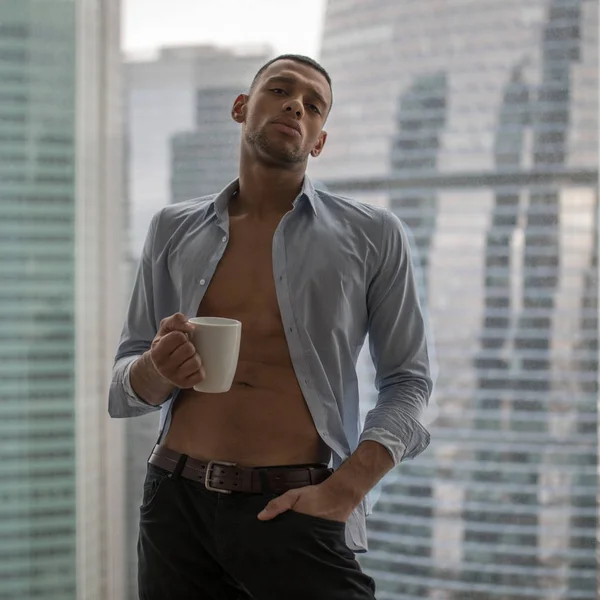 Bir işadamı bir sabah işe gitmeden önce kahve içiyor. Panoramik pencerelere arka plan. — Stok fotoğraf