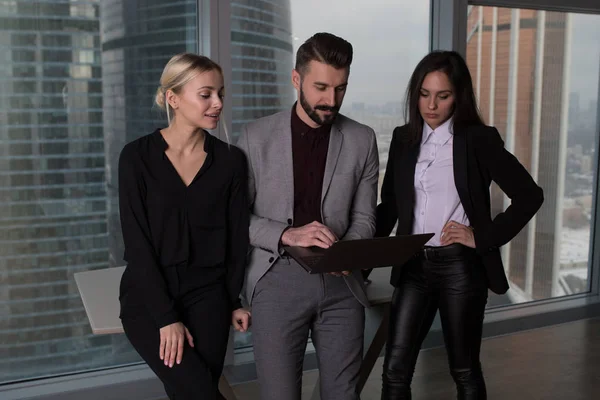Mensen uit het bedrijfsleven werken in een team voor een laptop. — Stockfoto