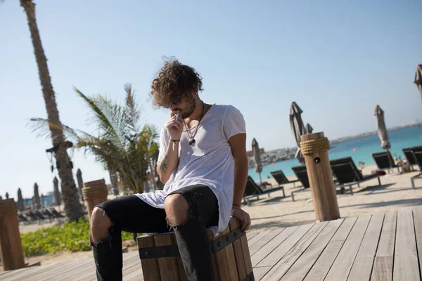 Homme élégant assis près de la plage et fumeur . — Photo