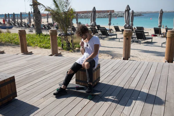 Homme élégant assis près de la plage et fumeur . — Photo