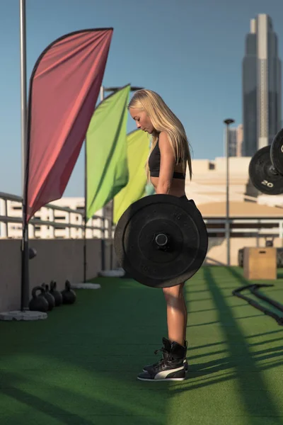 Jeune femme en forme avec haltère lourde faisant deadlift pour l'entraînement du dos . — Photo