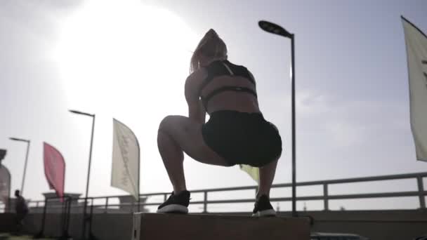 ボックス ジャンプを行う若い女性に合います。背面図. — ストック動画