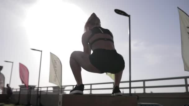 Ajuste mujer joven haciendo salto de caja. Vista trasera . — Vídeos de Stock