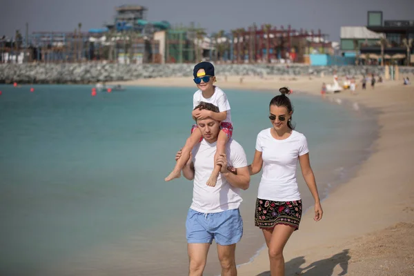 Szczęśliwa rodzina spacery wzdłuż plaży. — Zdjęcie stockowe