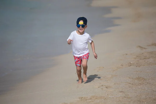 小男孩沿着海边奔跑。. — 图库照片
