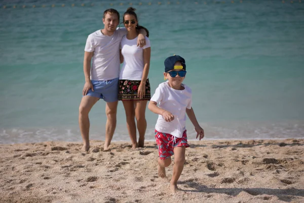 Lycklig familj stående på bakgrunden av havet. — Stockfoto