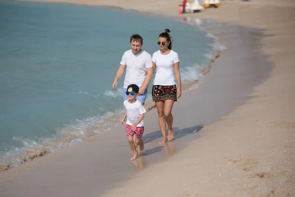 Szczęśliwa rodzina spacerując brzegiem morza. — Zdjęcie stockowe