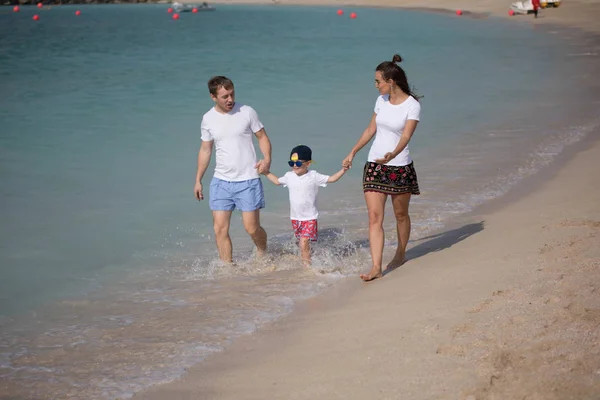 Szczęśliwa rodzina spacerując brzegiem morza. — Zdjęcie stockowe