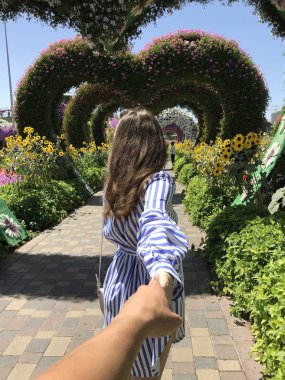 Bana çiçek kalpleri bir arka plan üzerinde güzel bir genç kız fotoğrafı izleyin.