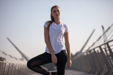 Spor kadında ise eğitim köprüsü üzerinde beyaz bir tişört. Mock-up.
