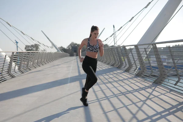 Femme active coureuse jogging à travers le pont, course en plein air, sport et mode de vie sain concept . — Photo